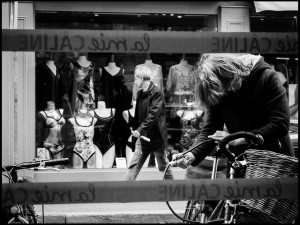Man walking past shop black and white