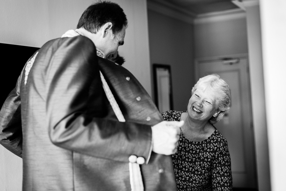 black and white picture of the mother of the groom laughing