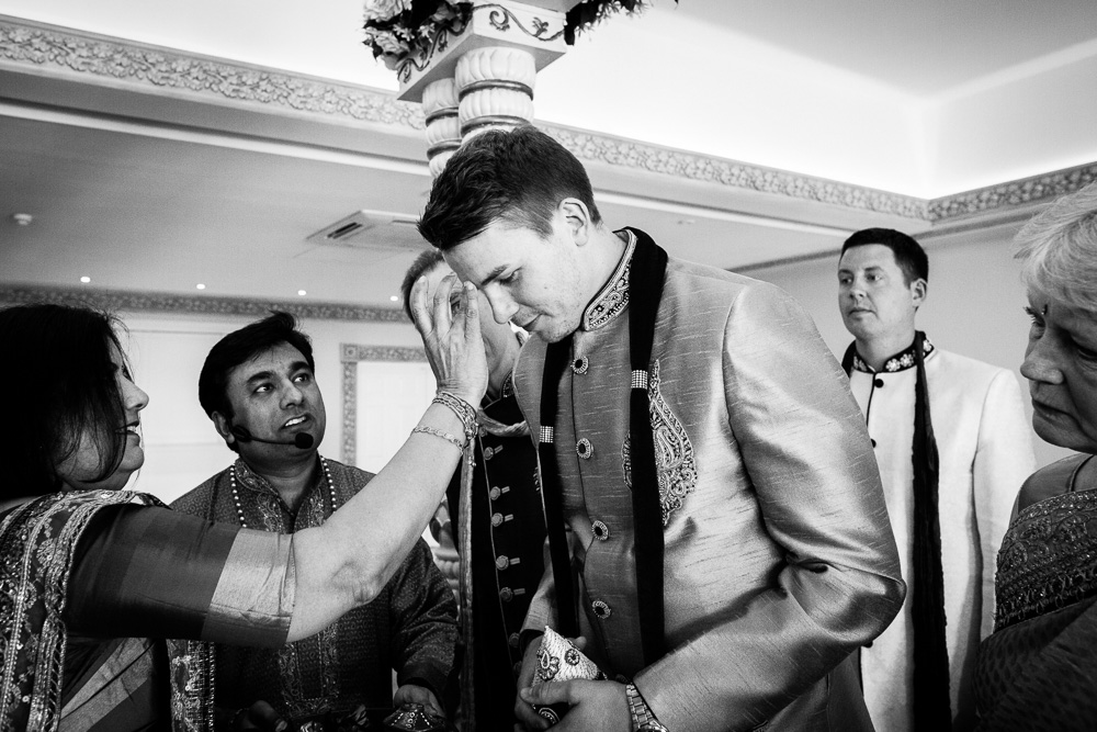 black and white picture of mother of the bride anointing the groom