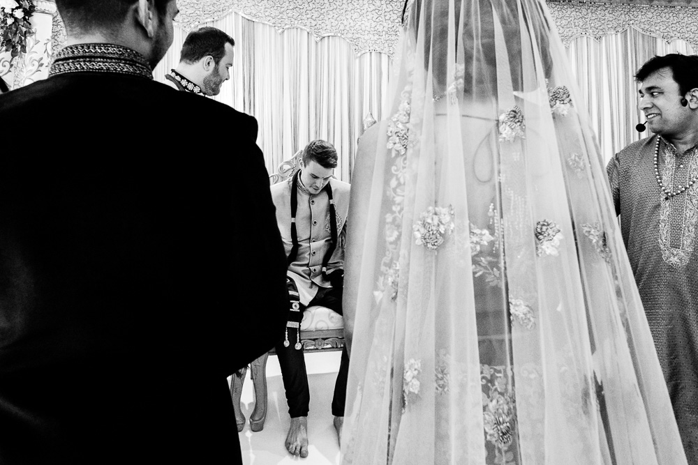 black and white picture of emotional groom seeing his bride