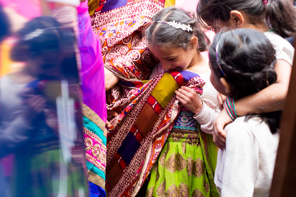 child hiding her her mother's sari