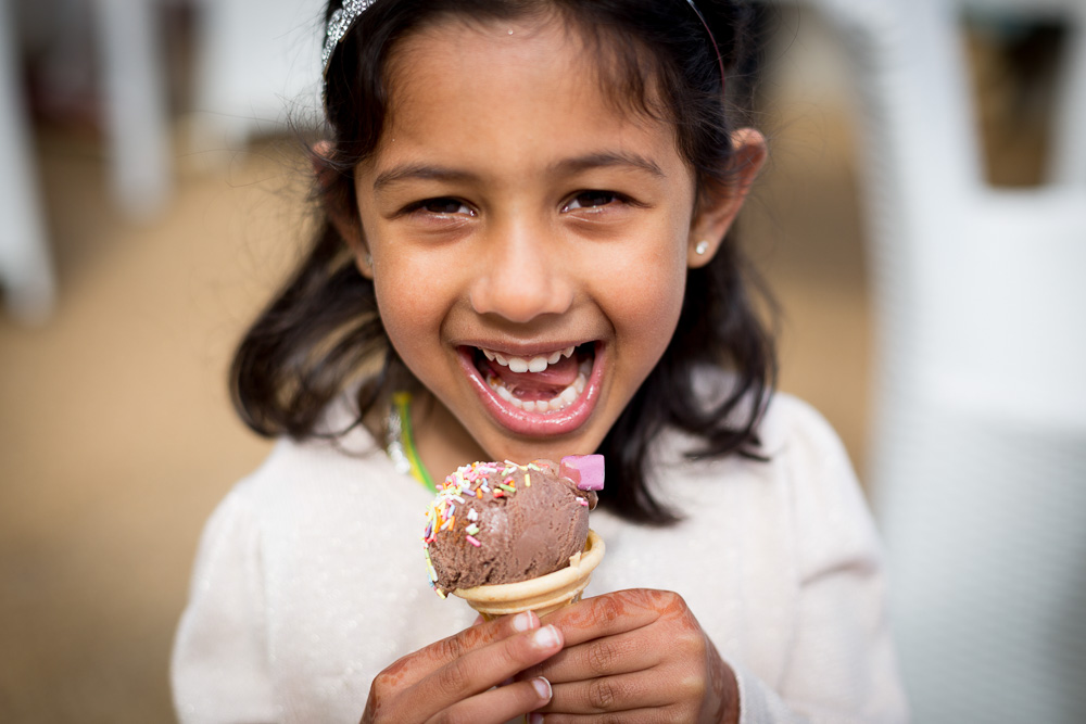 close up portrait of young wedding guest eating an ice cream