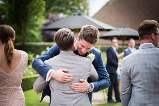 Groom hugging guest at The old Kent Barn