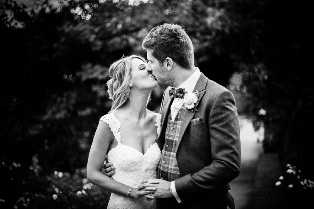 bride and groom kissing in black and white