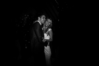 Bride and groom laughing during the first dance in black and white