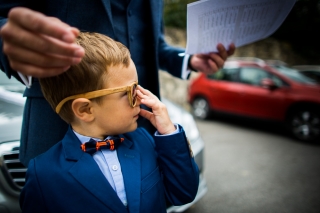 child wearing sunglasses looking at the groom