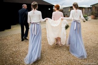 Bridesmaids holding up the bride's dress