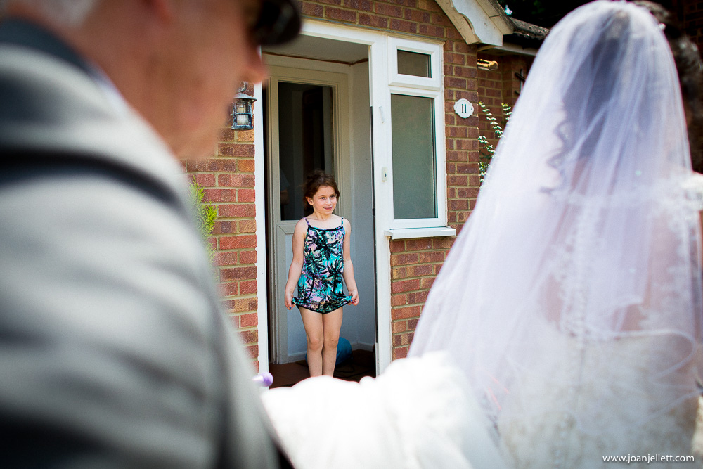 little girl looking at bride walking down the road