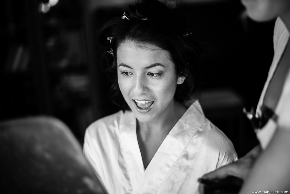black and white shot of bride laughing during prep