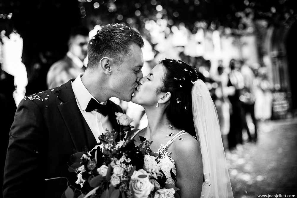 black and white shot of bride and groom kissing
