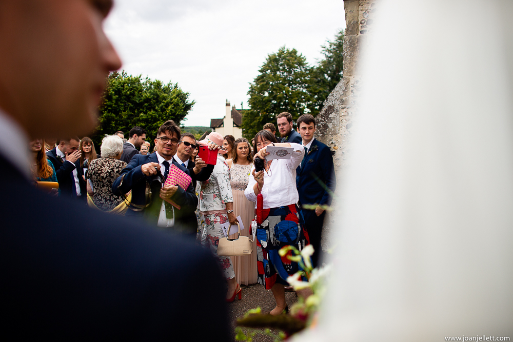 guests photographing bride and groom