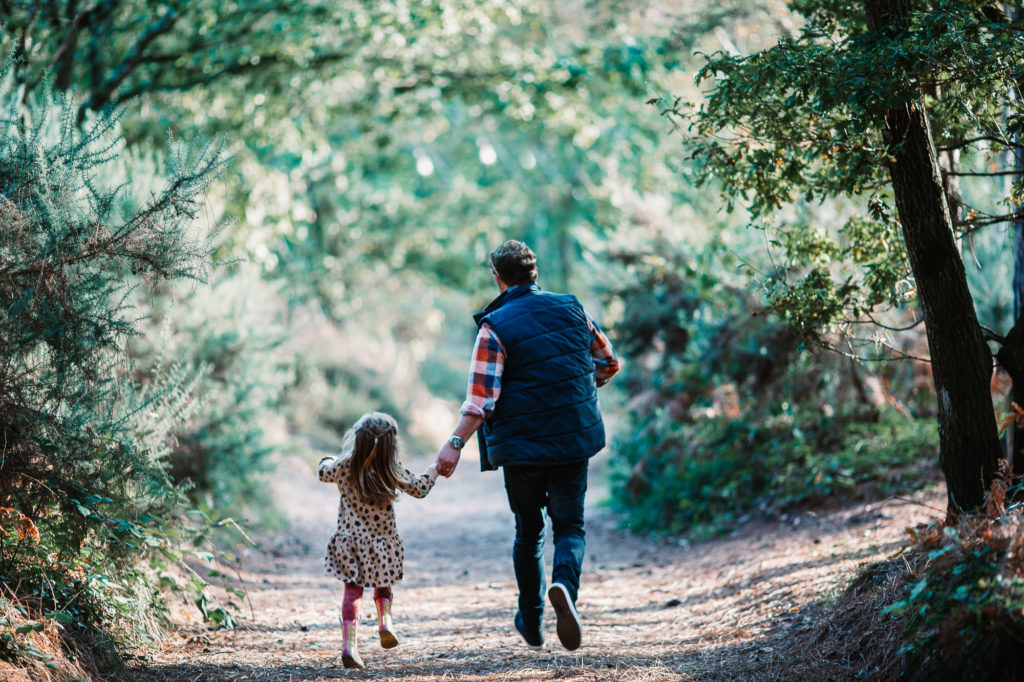Father running down the path whilst holding his daughter's hand