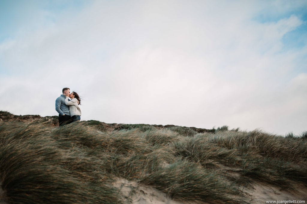 top of a hill couple kissing in hengistbury head