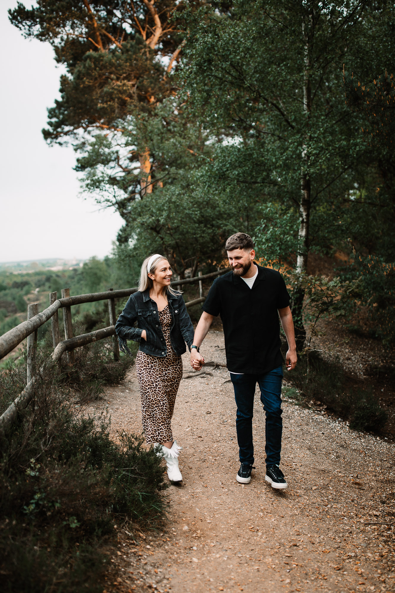 man and woman holding hands walking and smiling