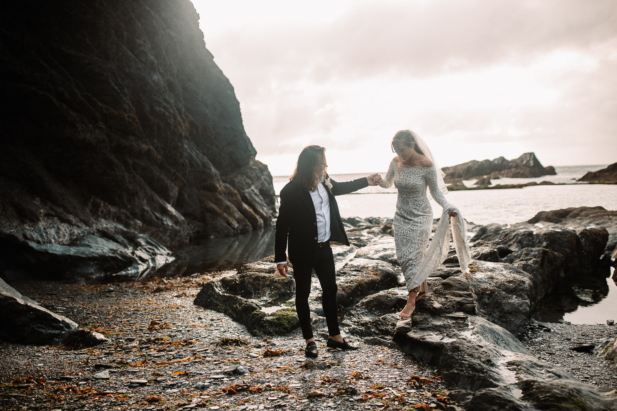 bride and groom walking holding hands at tunnels beaches golden hour