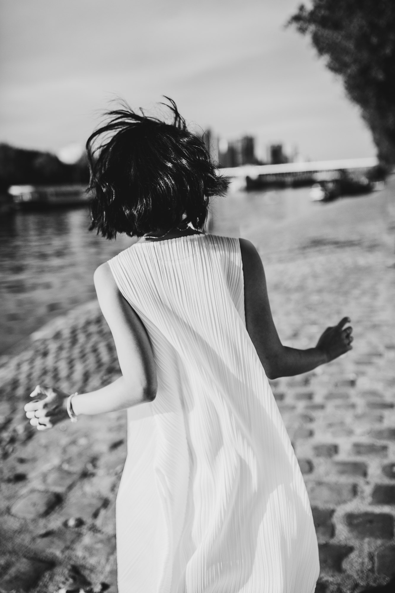 black and white backshot of bride running in Paris