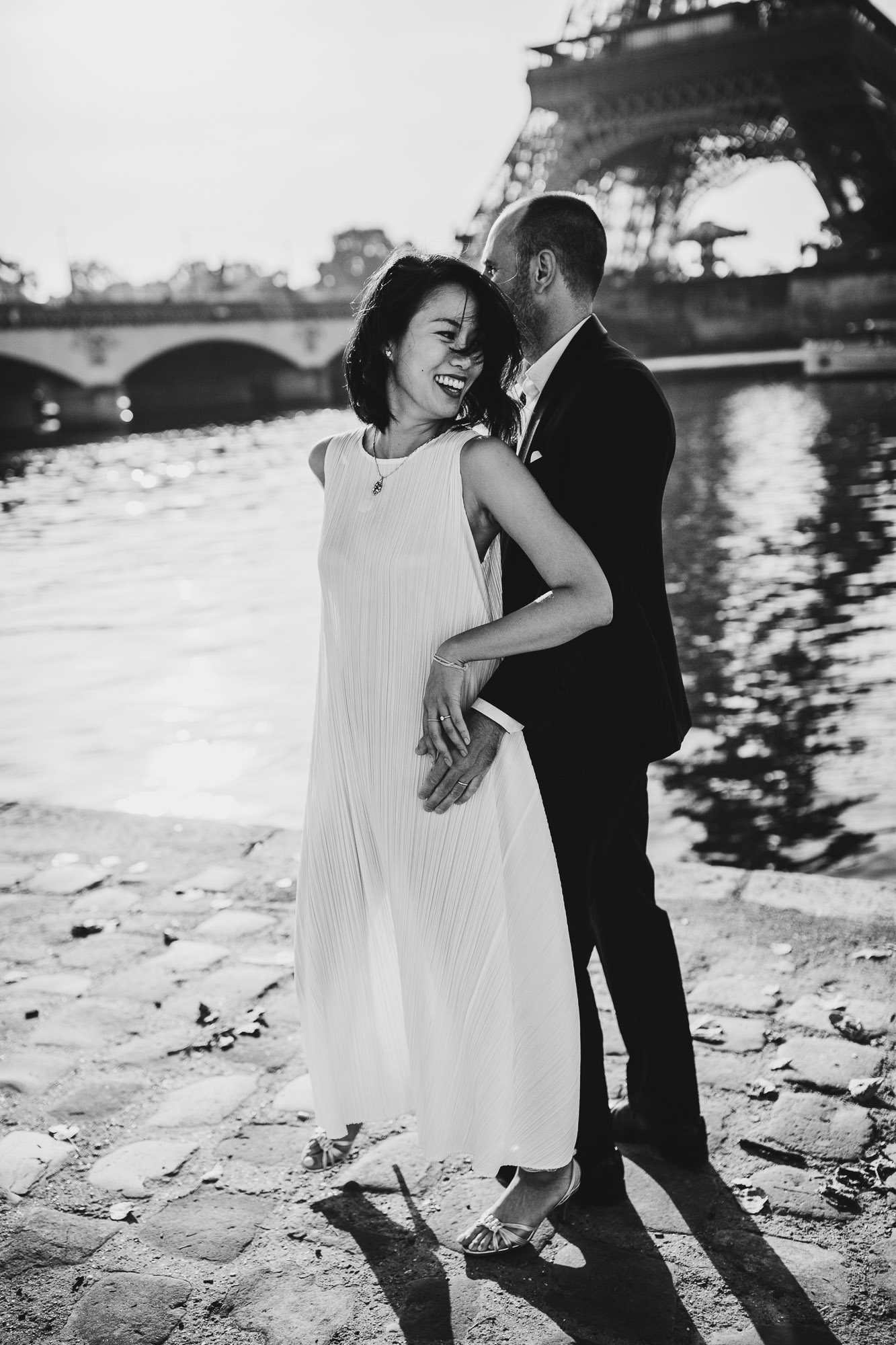 black and white shot of groom spooning bride in front eiffel tower