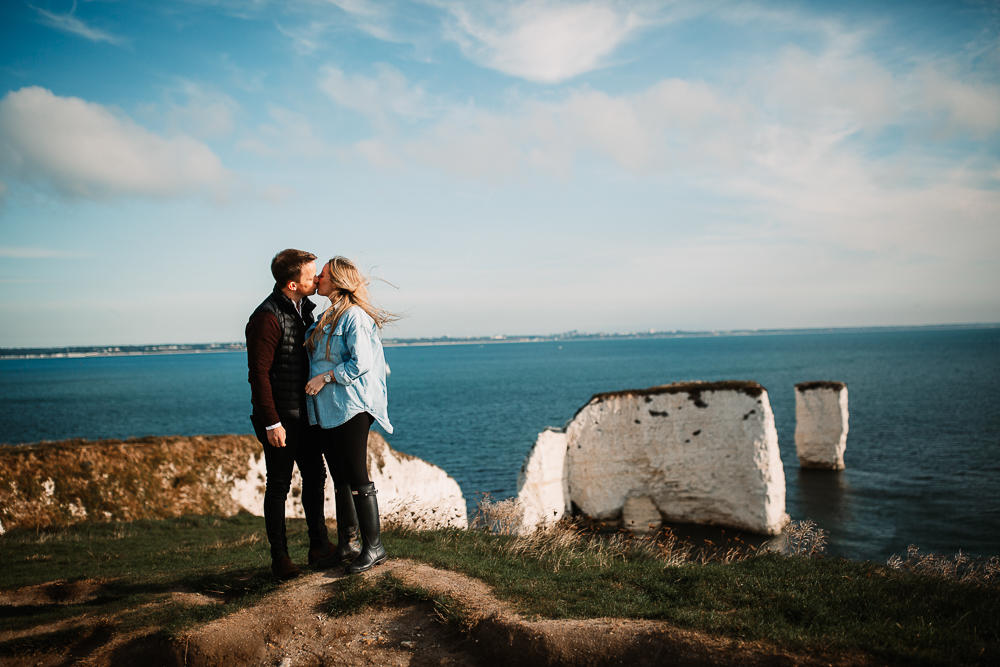 couple kissing with old harry rocks in the background