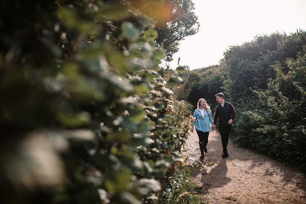 newly engaged couple walking hand in hand on their way to old harry rocks dorset