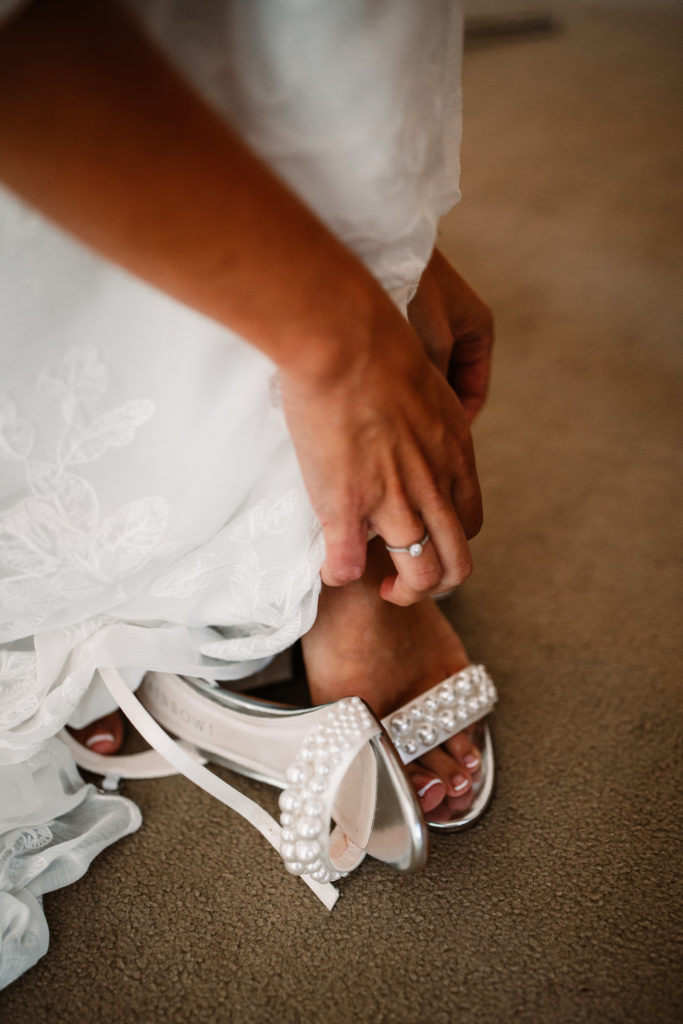 bride putting her shoes on, detail of the shoes