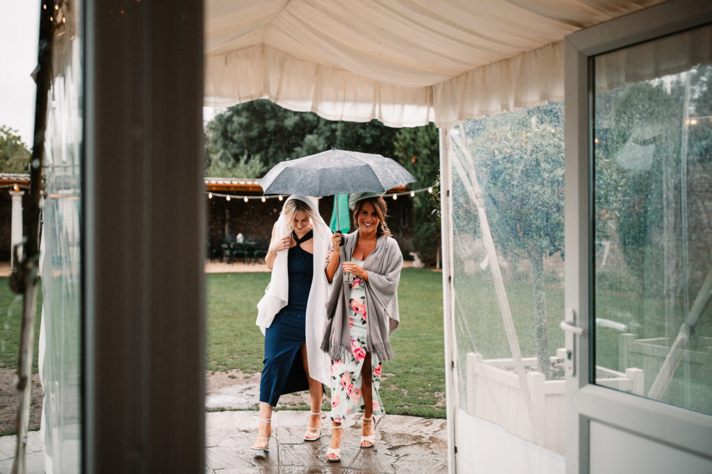 guests arriving under umbrellas in parley manor
