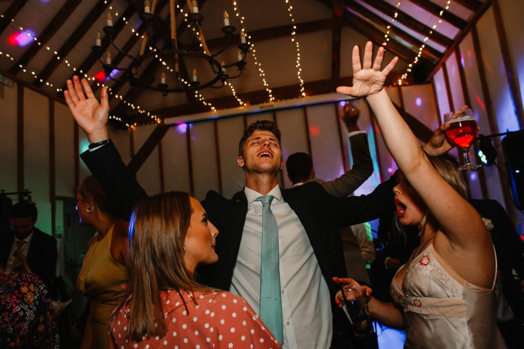 guest lifting arms in the air on the dancefloor