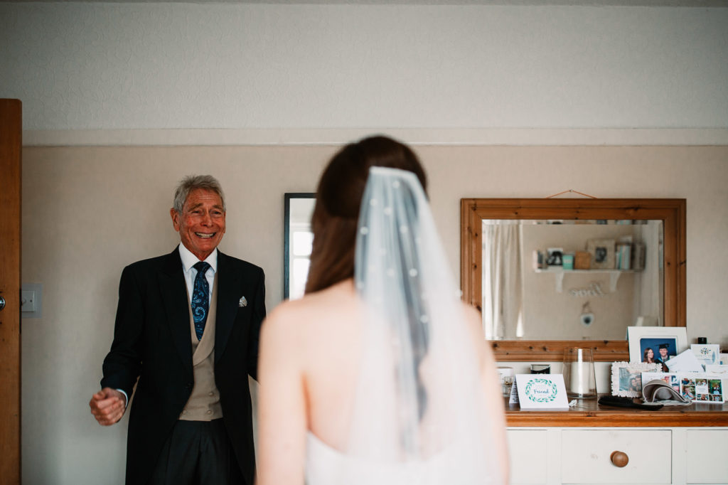 father of the bride seeing his daughter for the first time in her dress