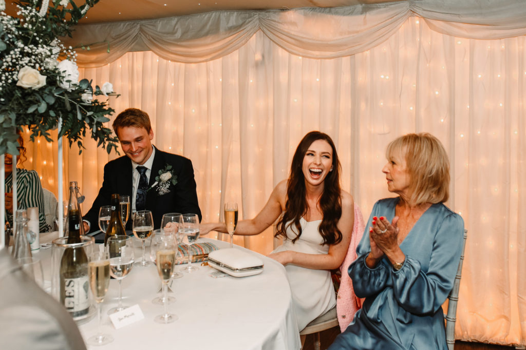 bride laughing at the speeches with her mum