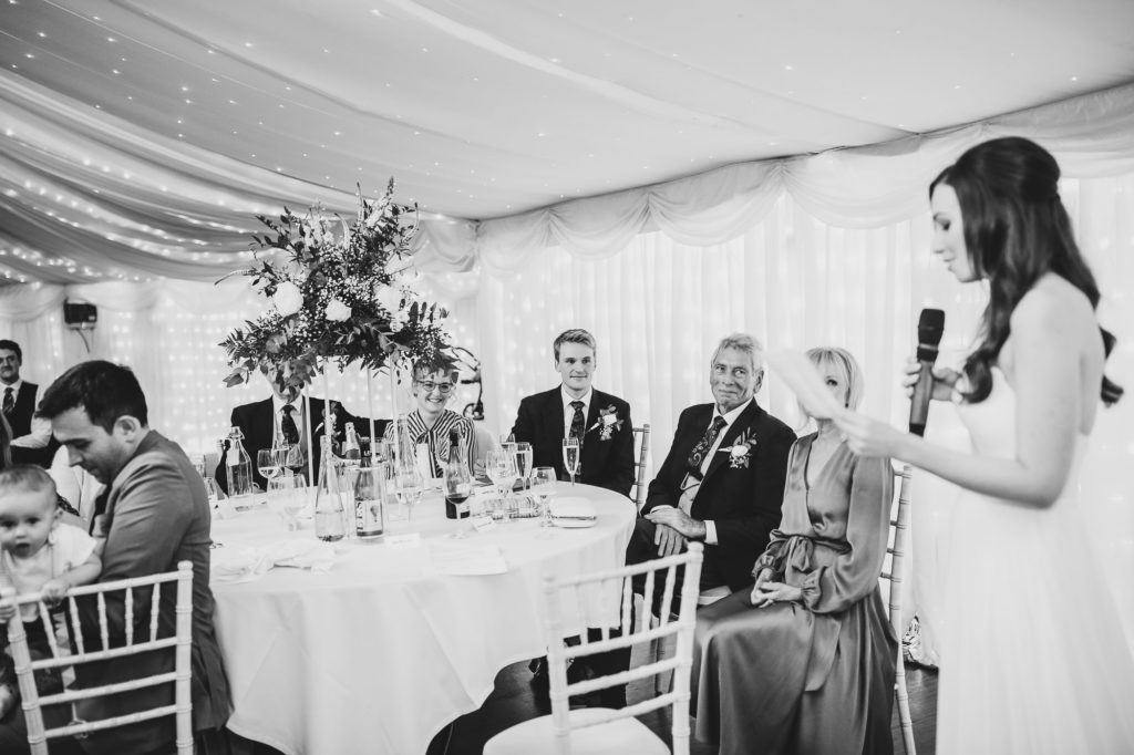 black and white shot of bride reading out a speech