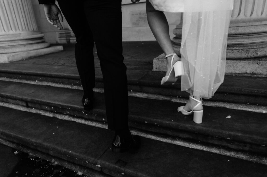 bride and groom walking up the stairs in black and white