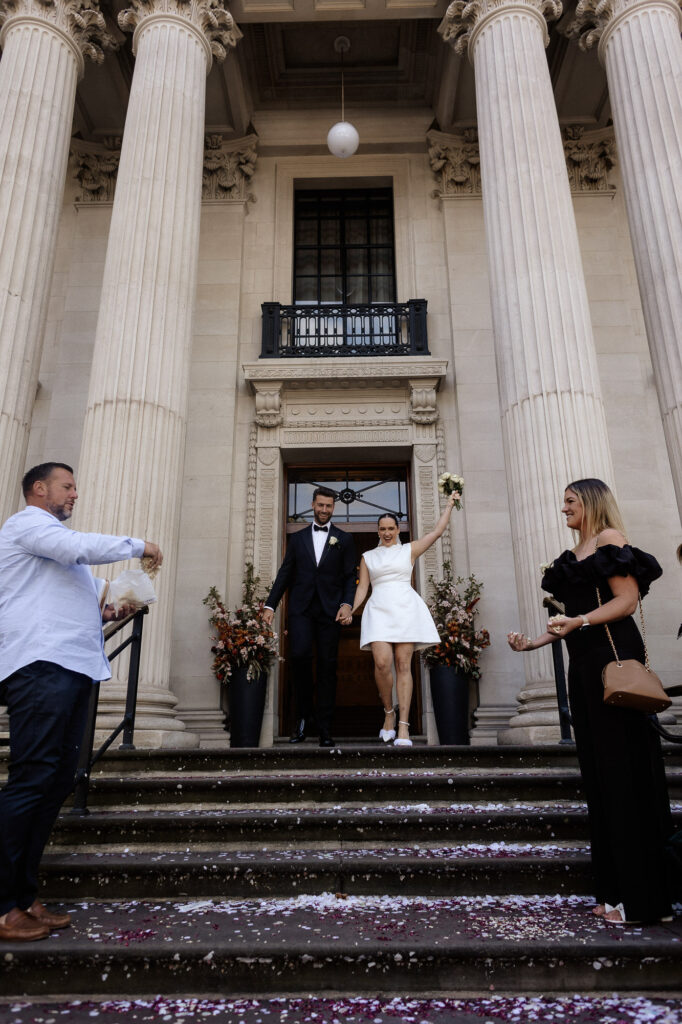 bride and groom about to walk down the stairs of Marylebone old town hall