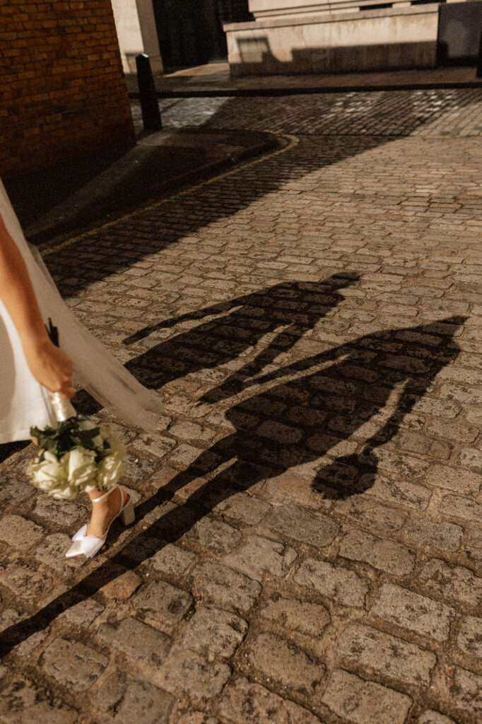 shadow of bride and groom walking in the sunshine