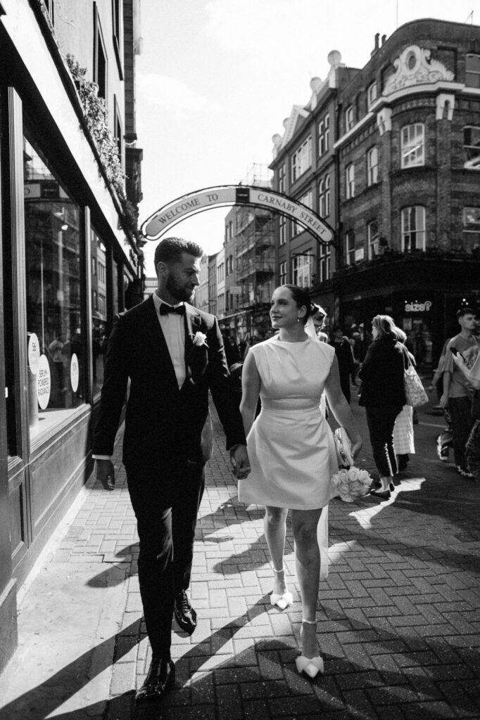 bride and groom walking hand in hand in Carnaby street