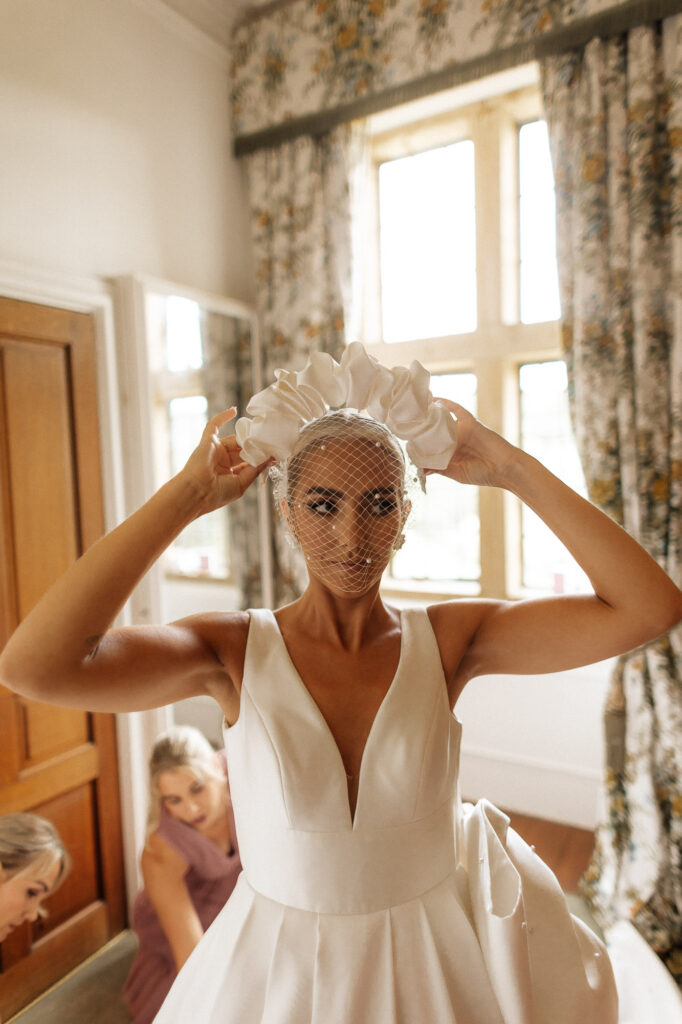 bride adjusting her head piece