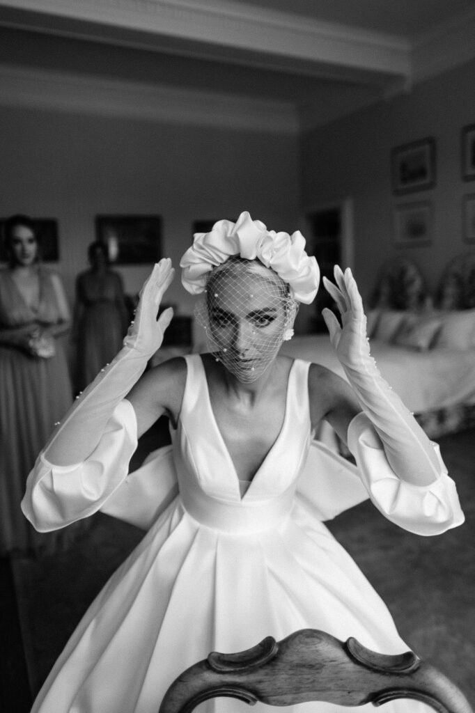 black and white shot of bride adjusting her hair in the mirror