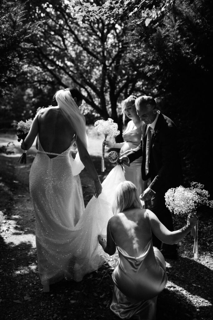 black and white shot of the dress being adjusted moments before walking down the aisle