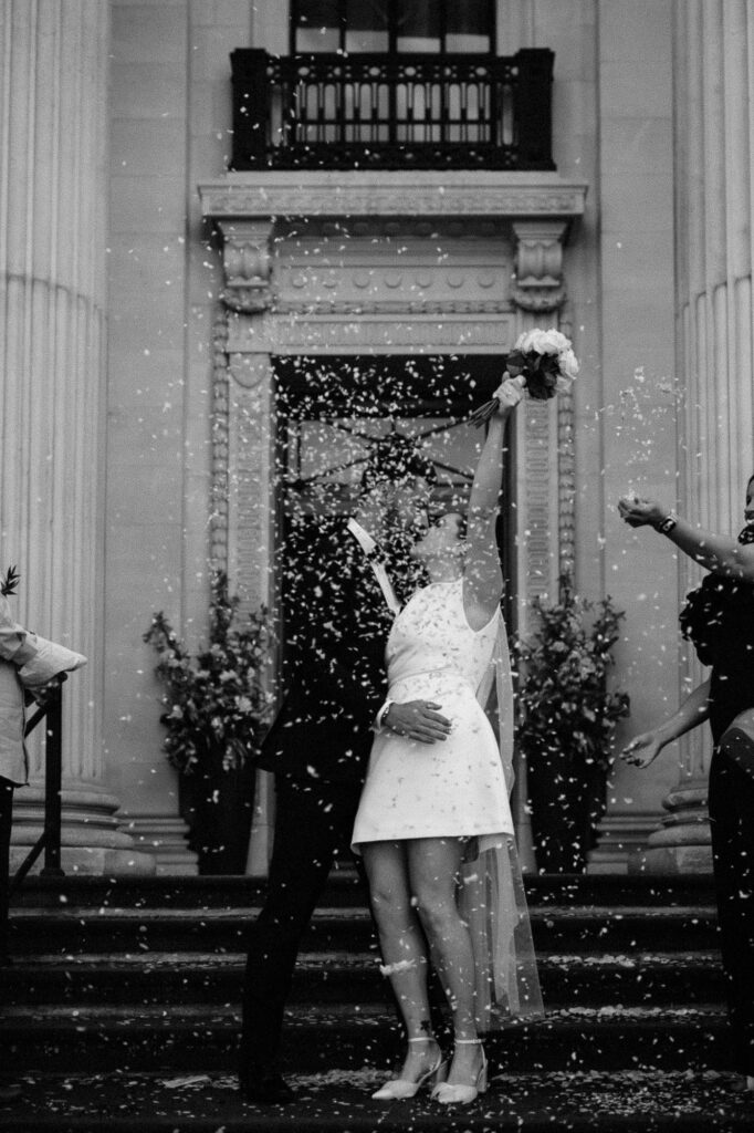 black and white shot of bride and groom in the confetti aisle in Marylebone