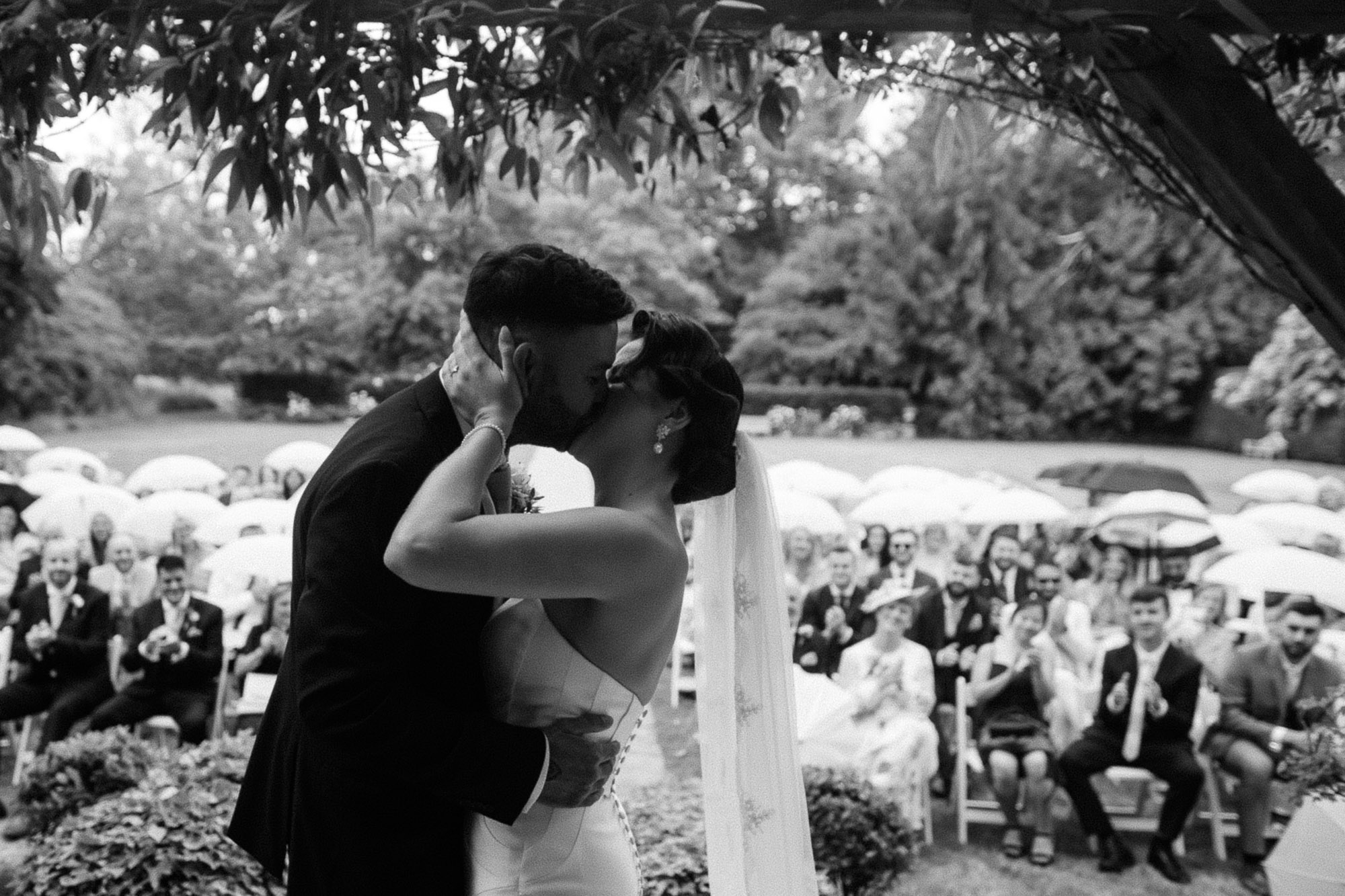 close up kiss shot in black and white of bride and groom at deans court