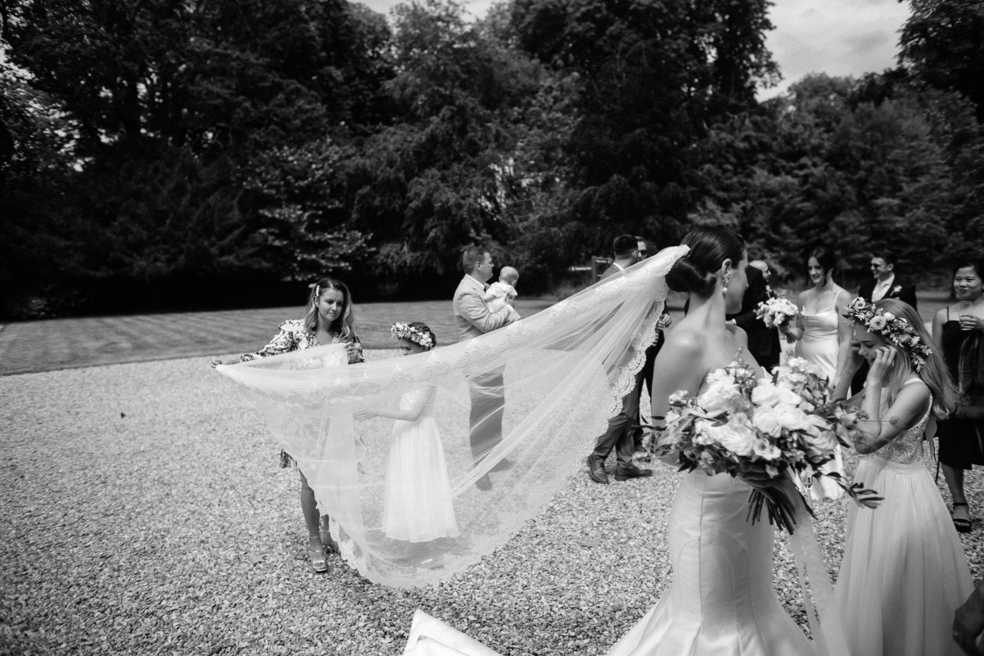 black and white shot of veil being arranged by one of the guests