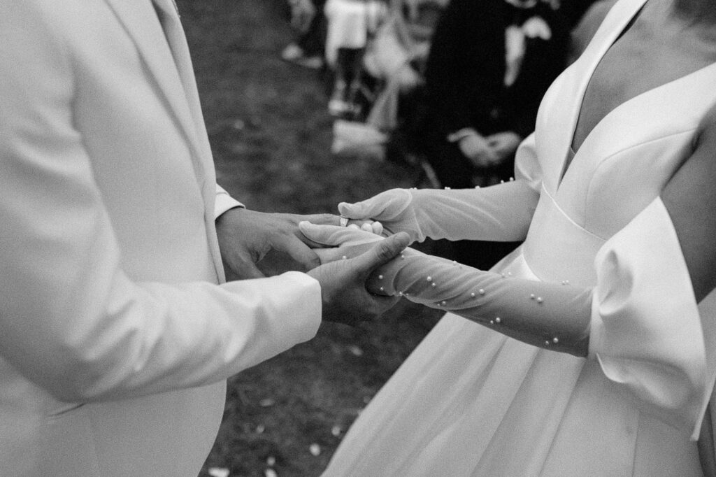 close up shot of bride and groom holding hands in black and white