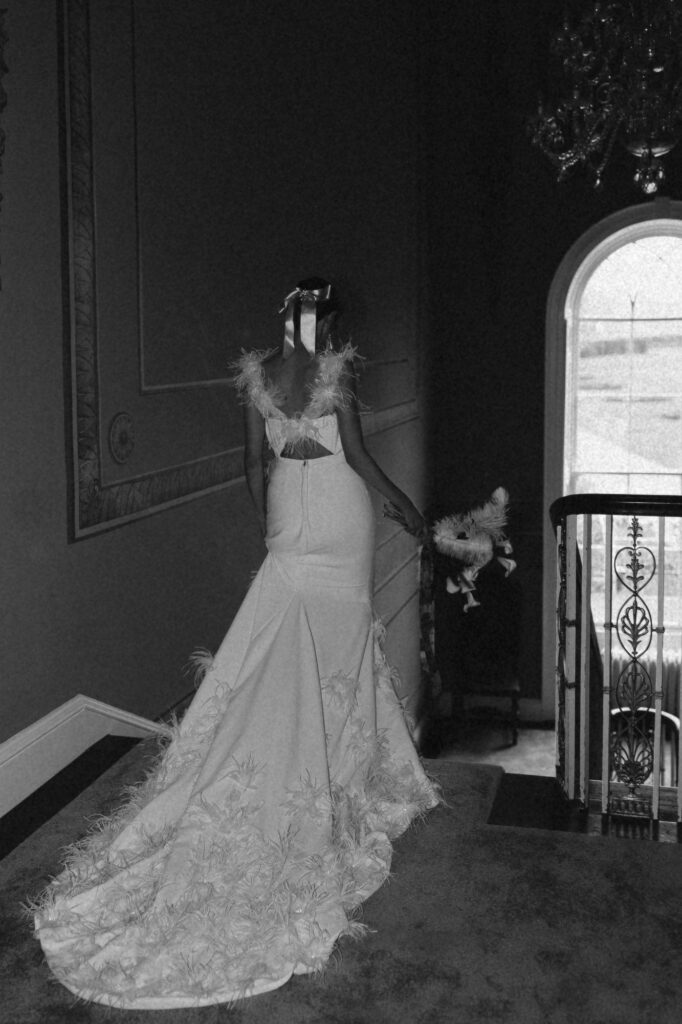 bride walking dow the stairs holding her bouquet at Avington Park